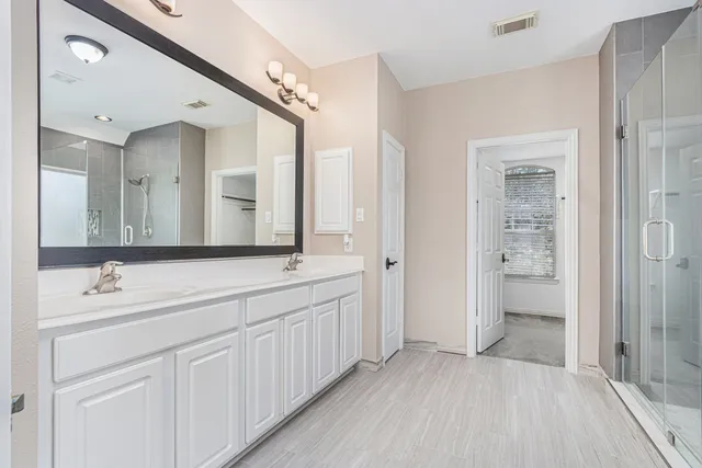 a bathroom with a double vanity sink and mirror