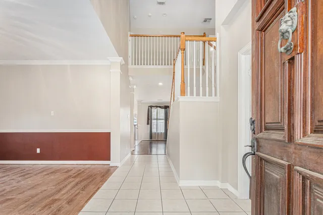 a view of a hallway with wooden floor and staircase