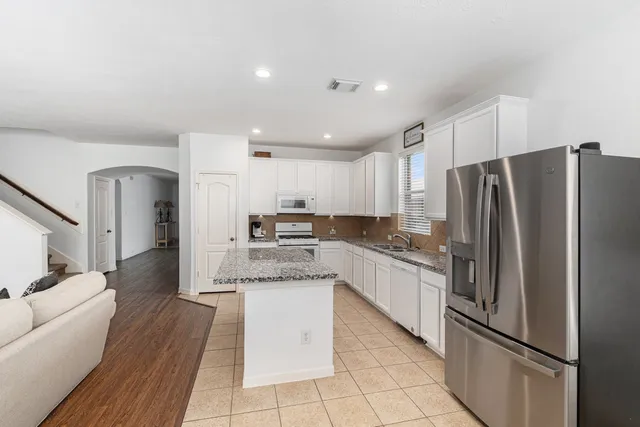 a kitchen with stainless steel appliances a refrigerator sink and cabinets