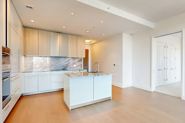 a kitchen with granite countertop white cabinets and white appliances