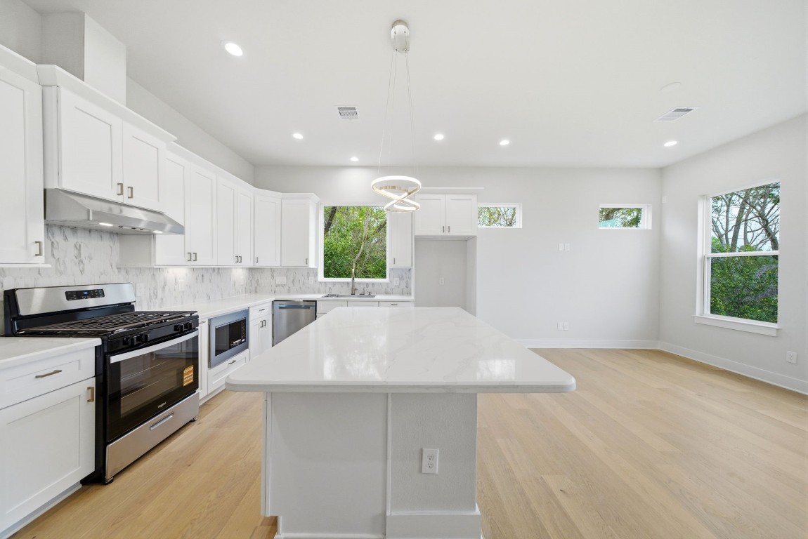 328 Janisch Road, Unit D Houston, TX 77018 - Photo 17 of 37 a large kitchen with stainless steel appliances a large counter top a stove a sink and a refrigerator