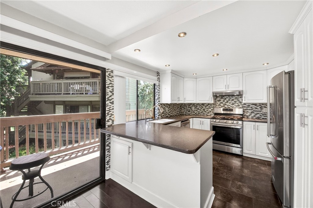 9 Madrona Irvine, CA 92612 - Photo 10 of 38 a kitchen with stainless steel appliances granite countertop a stove a sink and a refrigerator