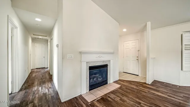 a view of a livingroom with wooden floor and a fireplace