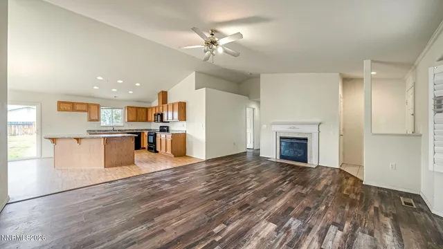a view of a kitchen with kitchen island wooden floor and a fireplace