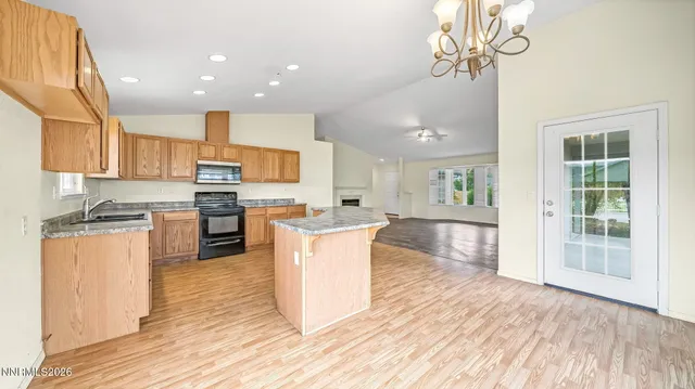 a kitchen with stainless steel appliances granite countertop a refrigerator a stove top oven a sink dishwasher and white cabinets with wooden floor
