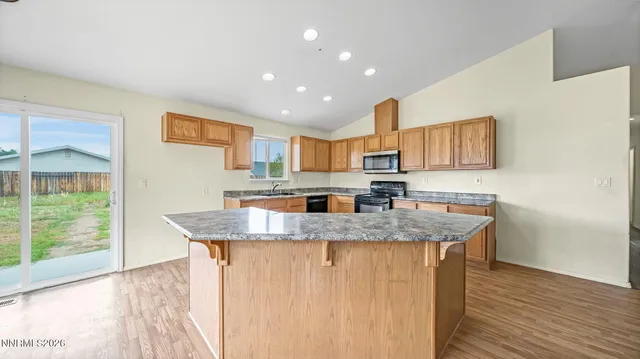 a kitchen with stainless steel appliances granite countertop a sink and a wooden floors