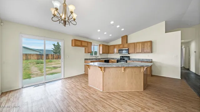 a kitchen with stainless steel appliances granite countertop a white cabinets and wooden floor