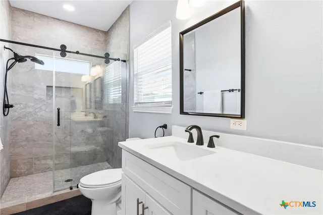 a view of a house with a yard and large tree