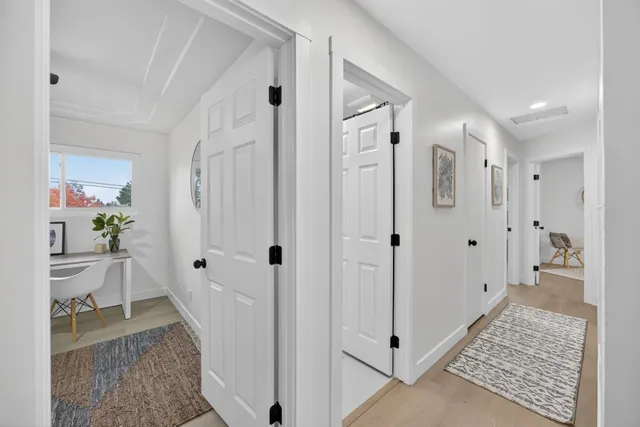 a hallway with painting on the wall and a large mirror