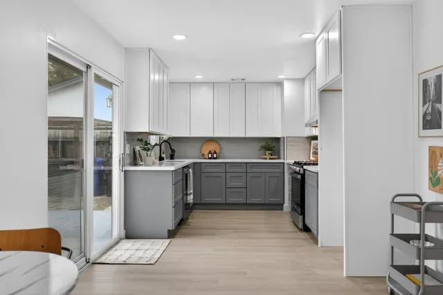 a view of a house with a yard and potted plants