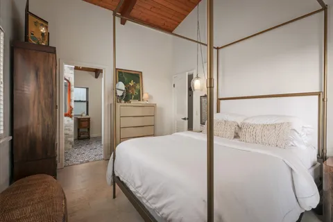 a bedroom with a bed and a refrigerator