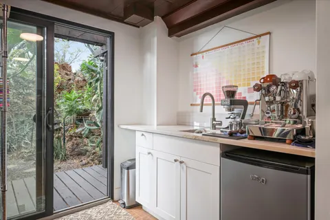 a kitchen with a sink and wooden floor