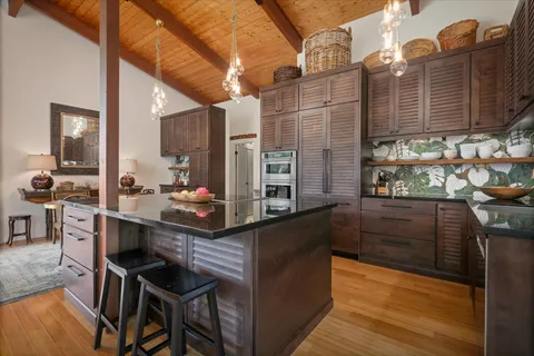 a kitchen with stainless steel appliances wooden cabinets and stove top oven