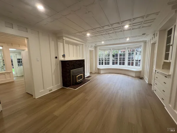 an empty room with wooden floor and fireplace