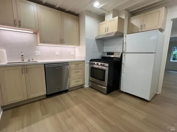 a kitchen with stainless steel appliances granite countertop a refrigerator sink and stove