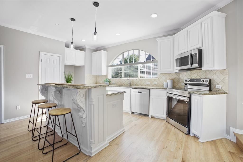 2700 Club Ridge Drive, Unit 2 Lewisville, TX 75067 - Photo 12 of 25 a kitchen with stainless steel appliances granite countertop a stove a sink and a microwave