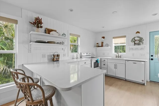 a kitchen with a dining table chairs cabinets and window