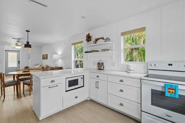 a kitchen with cabinets appliances and a window