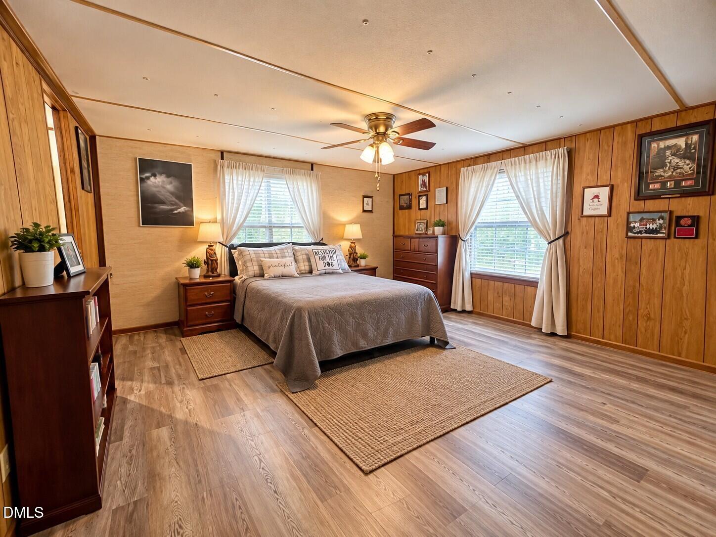 471 Kramer Road Lillington, NC 27546 - Photo 8 of 26 Wood-finish flooring throughout, with wood-paneled walls and a ceiling fan with integrated lighting
