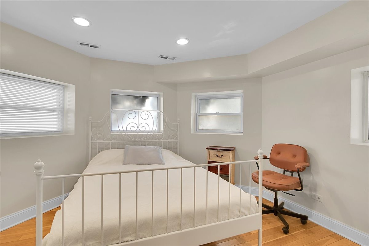 1647 West Sherwin Avenue, Unit 1 Chicago, IL 60626 - Photo 12 of 22 a bedroom with bed and a chandelier