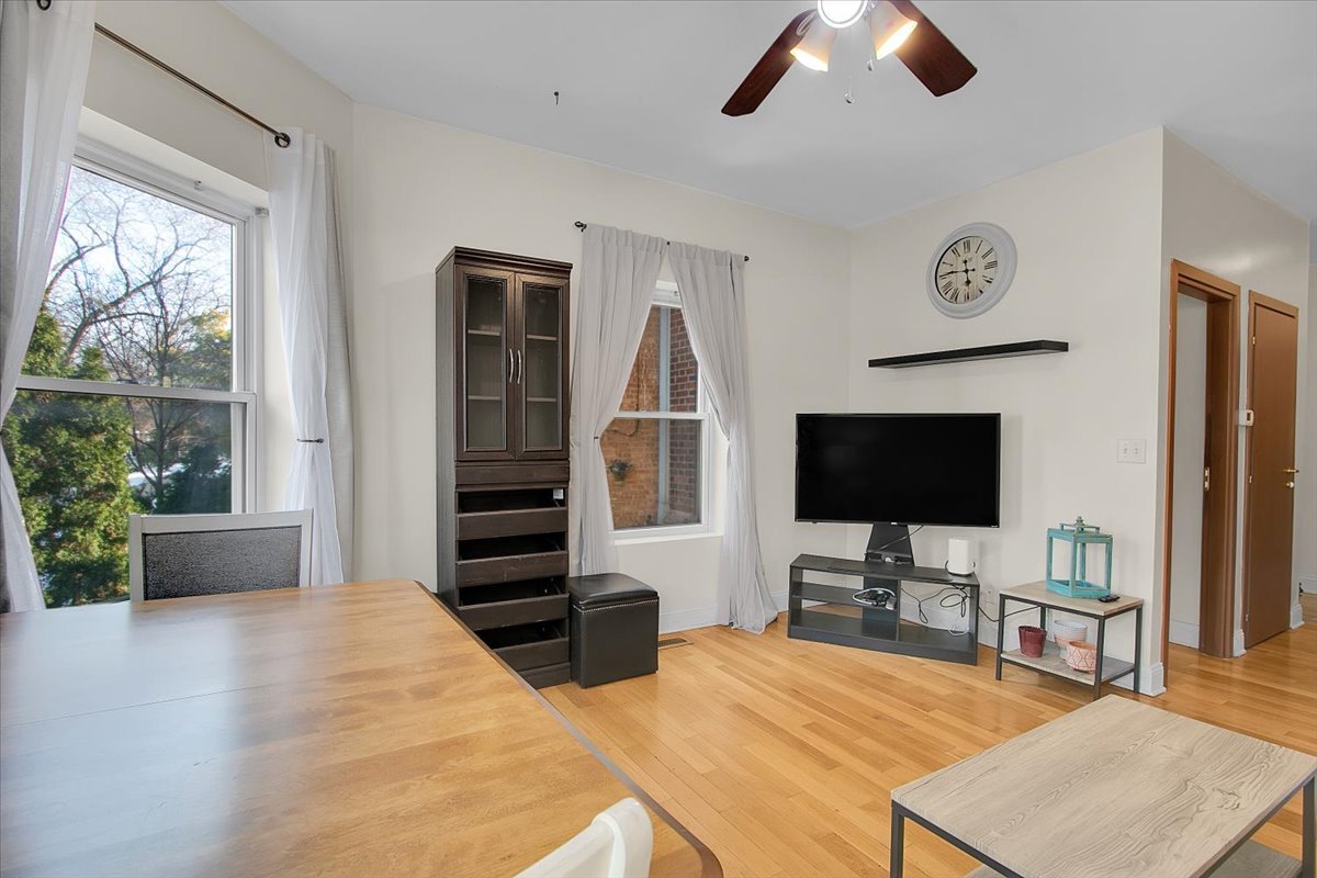 1647 West Sherwin Avenue, Unit 1 Chicago, IL 60626 - Photo 4 of 22 a bedroom with furniture and a flat screen tv