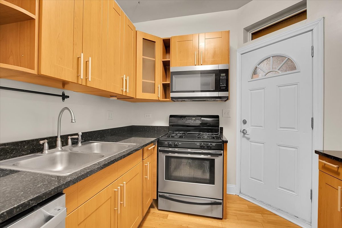 1647 West Sherwin Avenue, Unit 1 Chicago, IL 60626 - Photo 7 of 22 a kitchen with stainless steel appliances granite countertop a sink stove and microwave