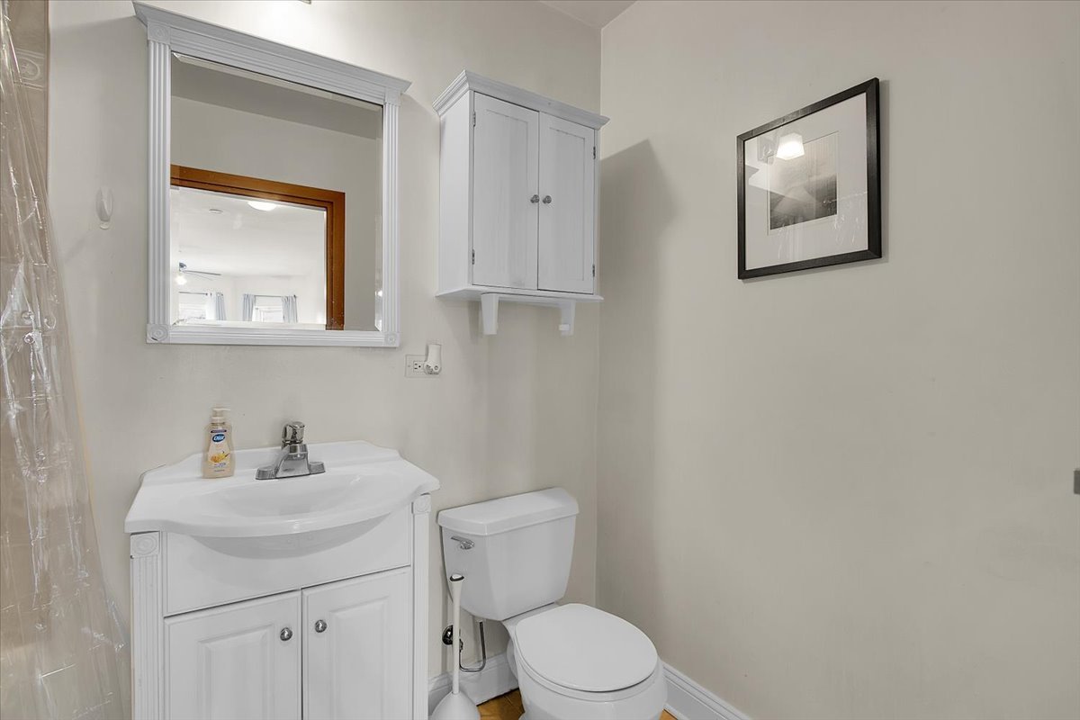 1647 West Sherwin Avenue, Unit 1 Chicago, IL 60626 - Photo 9 of 22 a bathroom with a toilet a sink and mirror