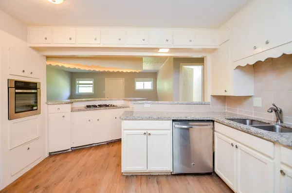 a kitchen with a sink cabinets and wooden floor
