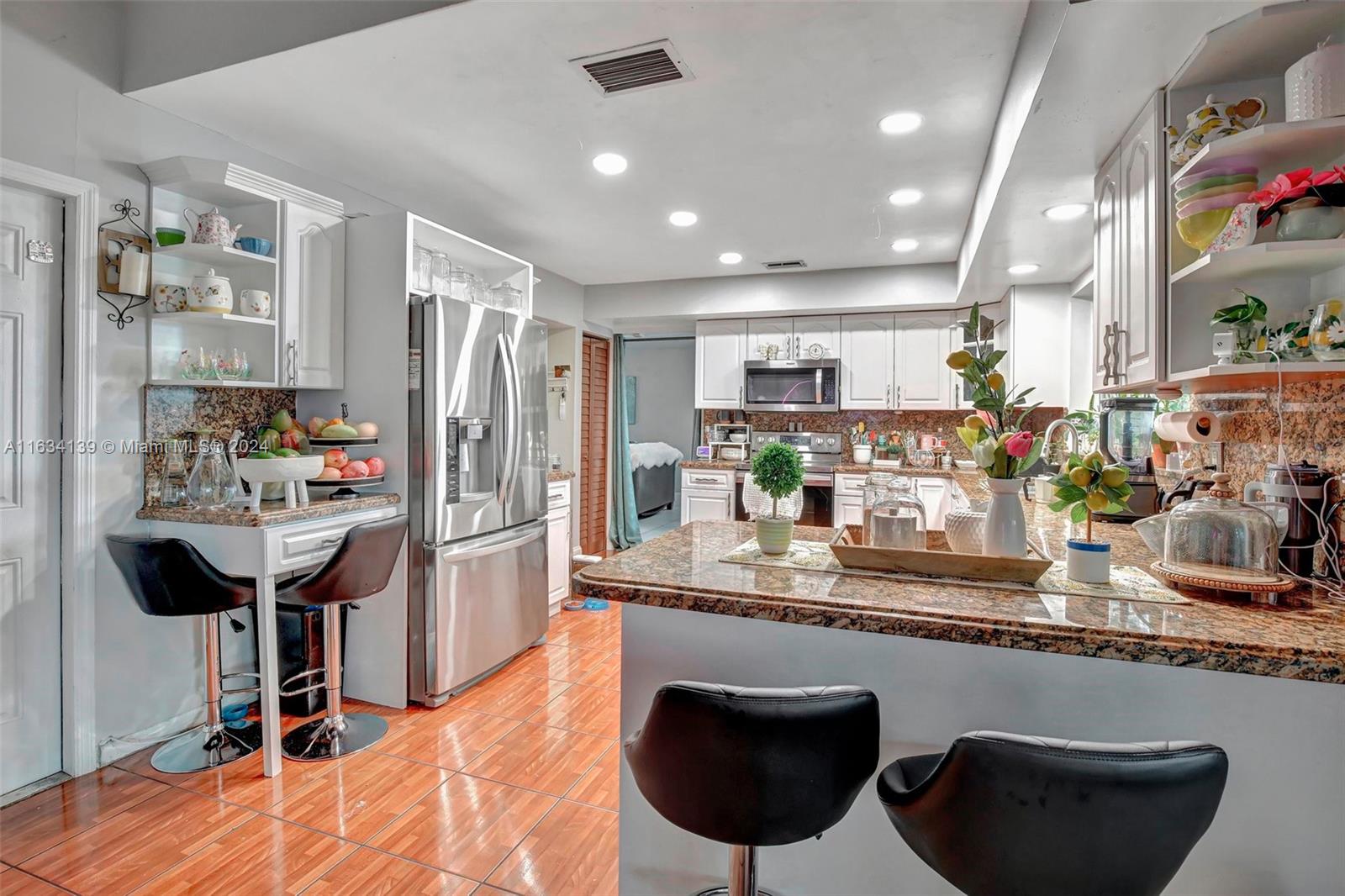 2860 Huron Way Miramar, FL 33025 - Photo 17 of 57 a kitchen with stainless steel appliances granite countertop a sink refrigerator and cabinets