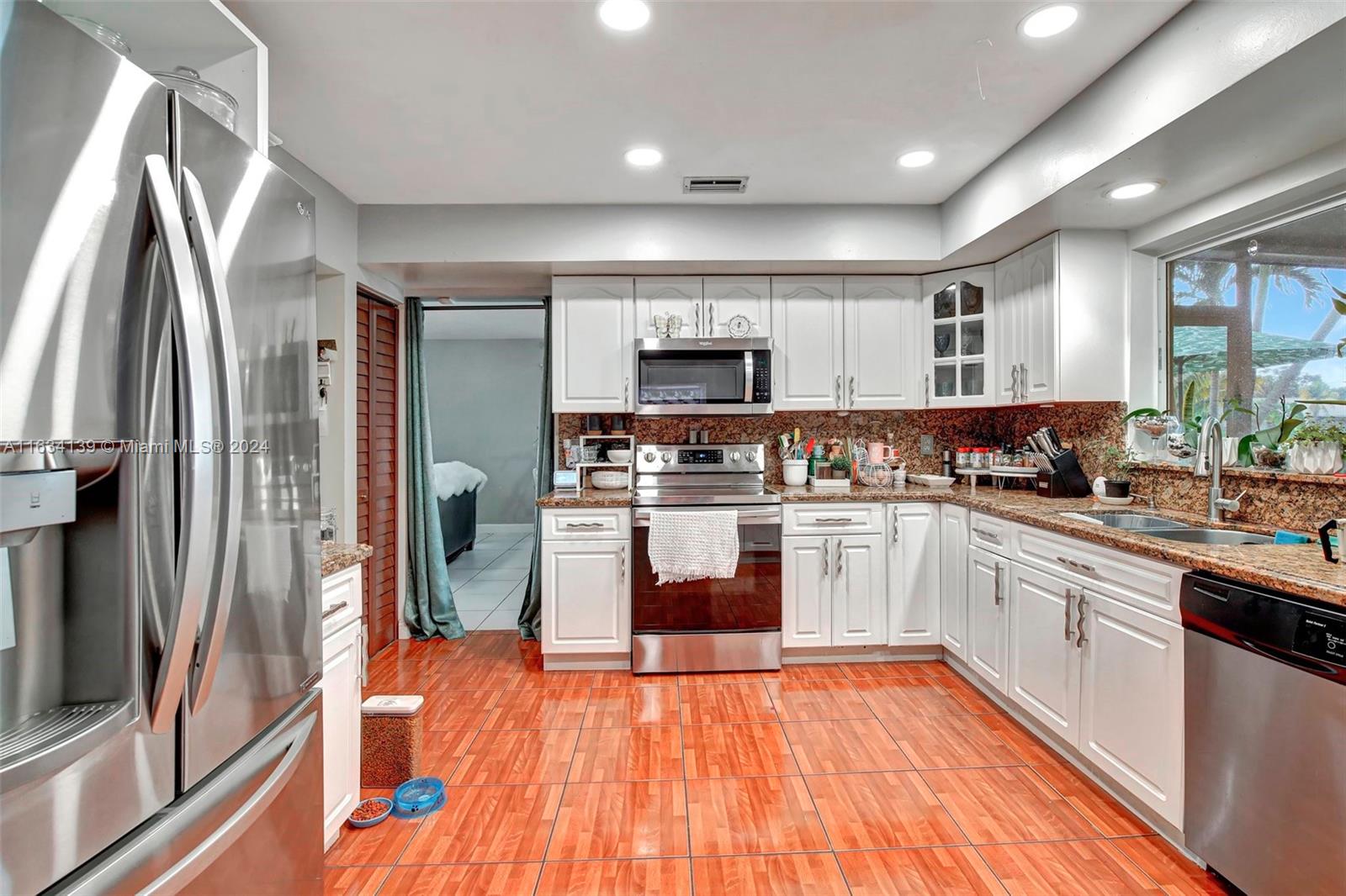 2860 Huron Way Miramar, FL 33025 - Photo 19 of 57 a kitchen with stainless steel appliances granite countertop a refrigerator and a stove top oven