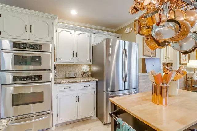 a kitchen with stainless steel appliances granite countertop a sink a stove and refrigerator