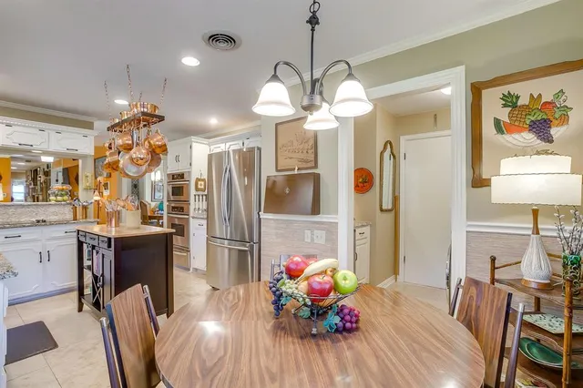 a view of a dining room with furniture a chandelier and wooden floor