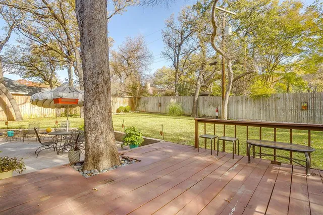 a view of backyard with outdoor seating and trees