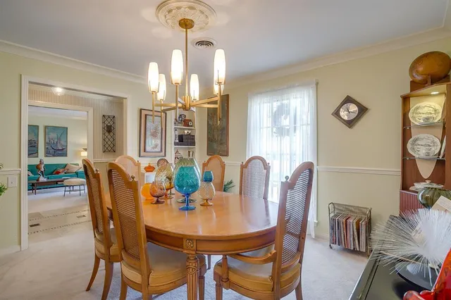 a dining room with furniture a chandelier and window