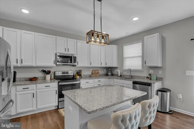 a kitchen with stainless steel appliances granite countertop a sink a stove and a center island