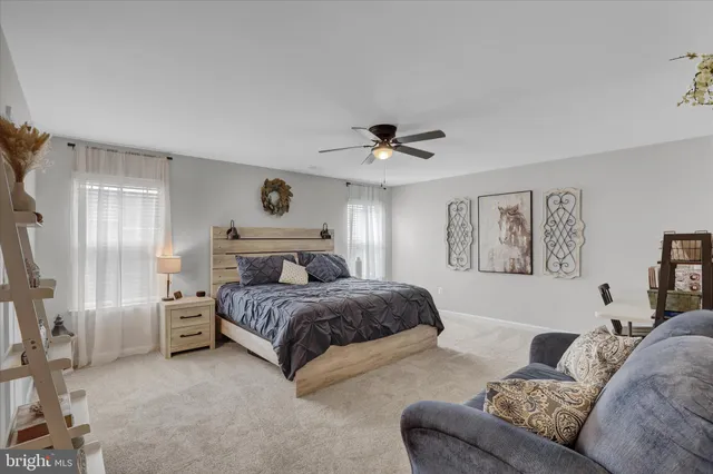 a spacious bedroom with a bed a couch and a chandelier