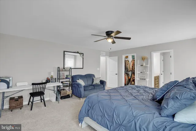 a spacious bedroom with a bed a desk and chair