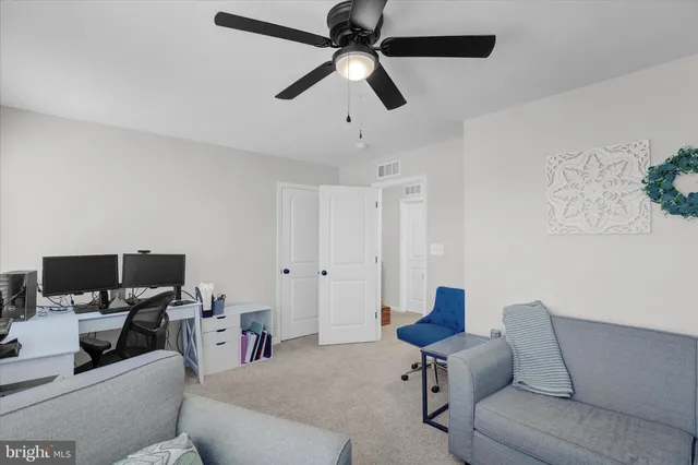 a living room with furniture and a view of kitchen
