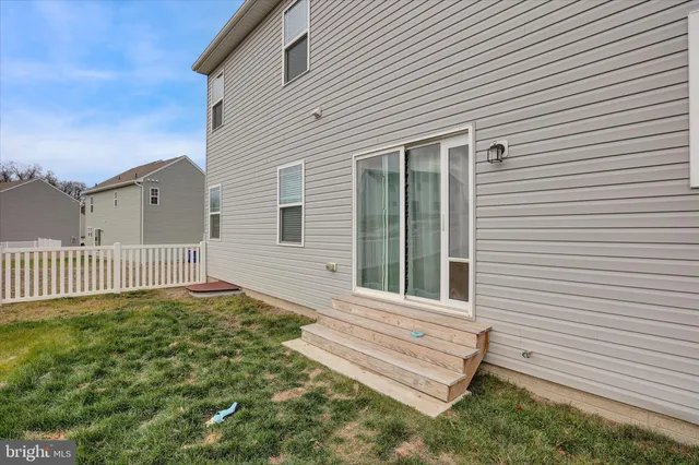 a view of a house with a small yard and wooden floor and fence