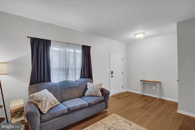 a living room with a couch and a dresser with wooden floor