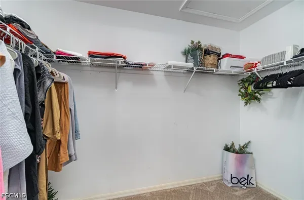 a view of walk in closet with clothes and shoes
