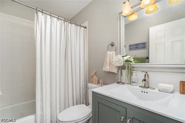a bathroom with a sink vanity mirror and toilet