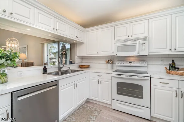 a kitchen with white cabinets and white appliances