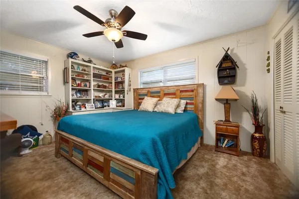 a bedroom with a bed and a ceiling fan