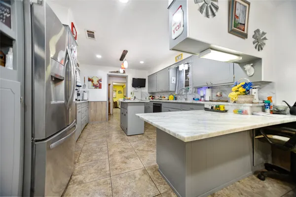 a kitchen with stainless steel appliances granite countertop a refrigerator and a sink