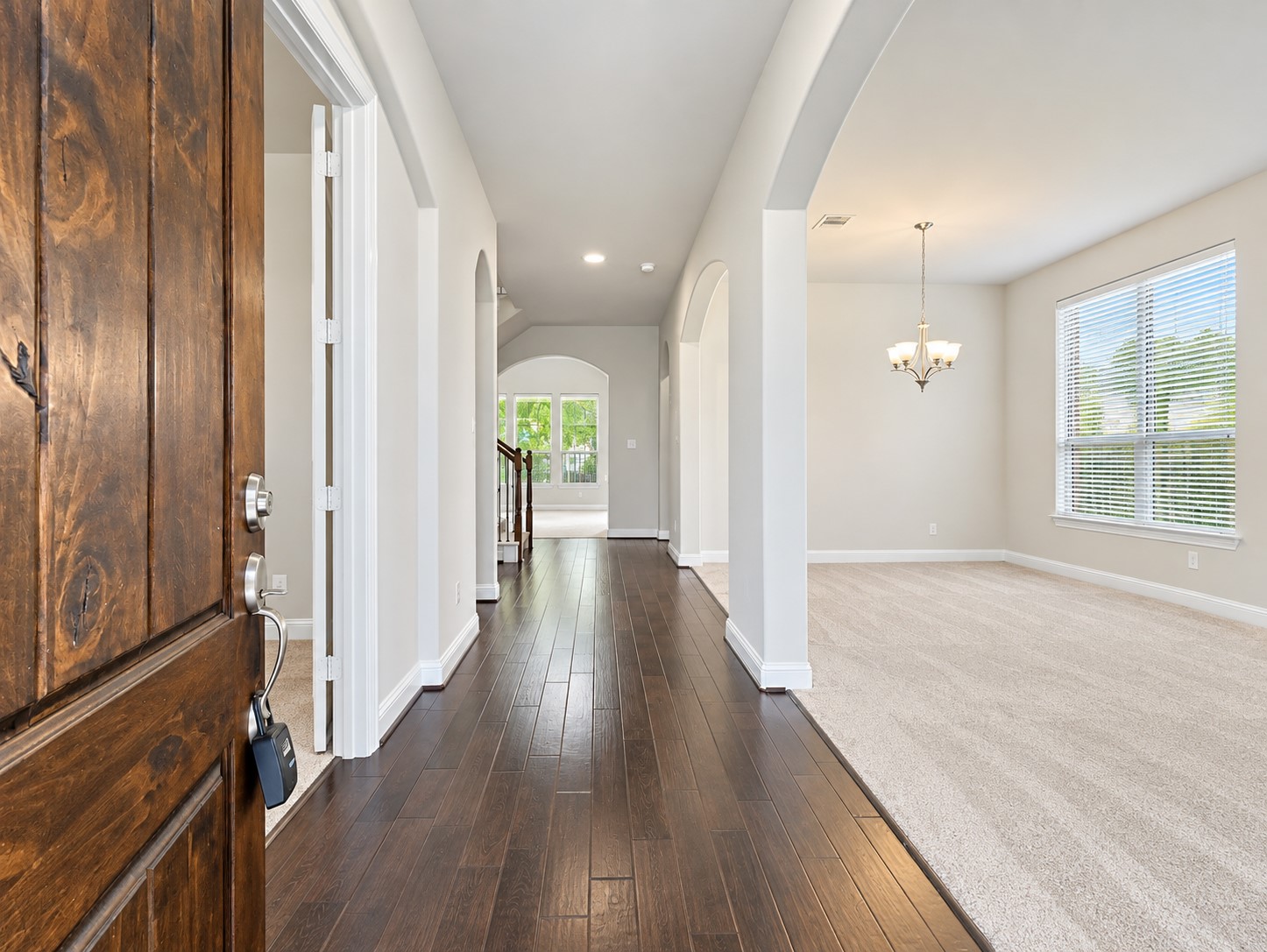 9626 Invergarry Way Tomball, TX 77375 - Photo 3 of 43 Welcoming entryway with rich wood flooring, arched architectural details, and a view toward the main living areas.