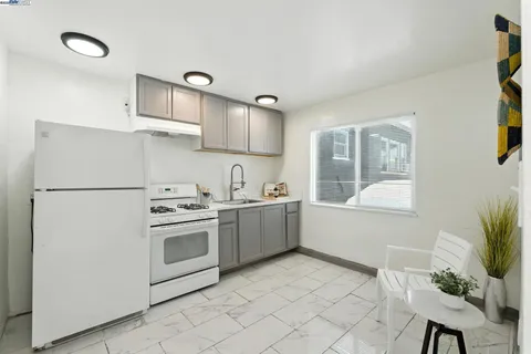 a kitchen with cabinets appliances a sink and a window