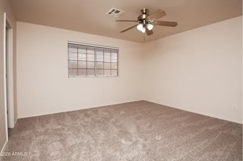 an empty room with a window and a ceiling fan
