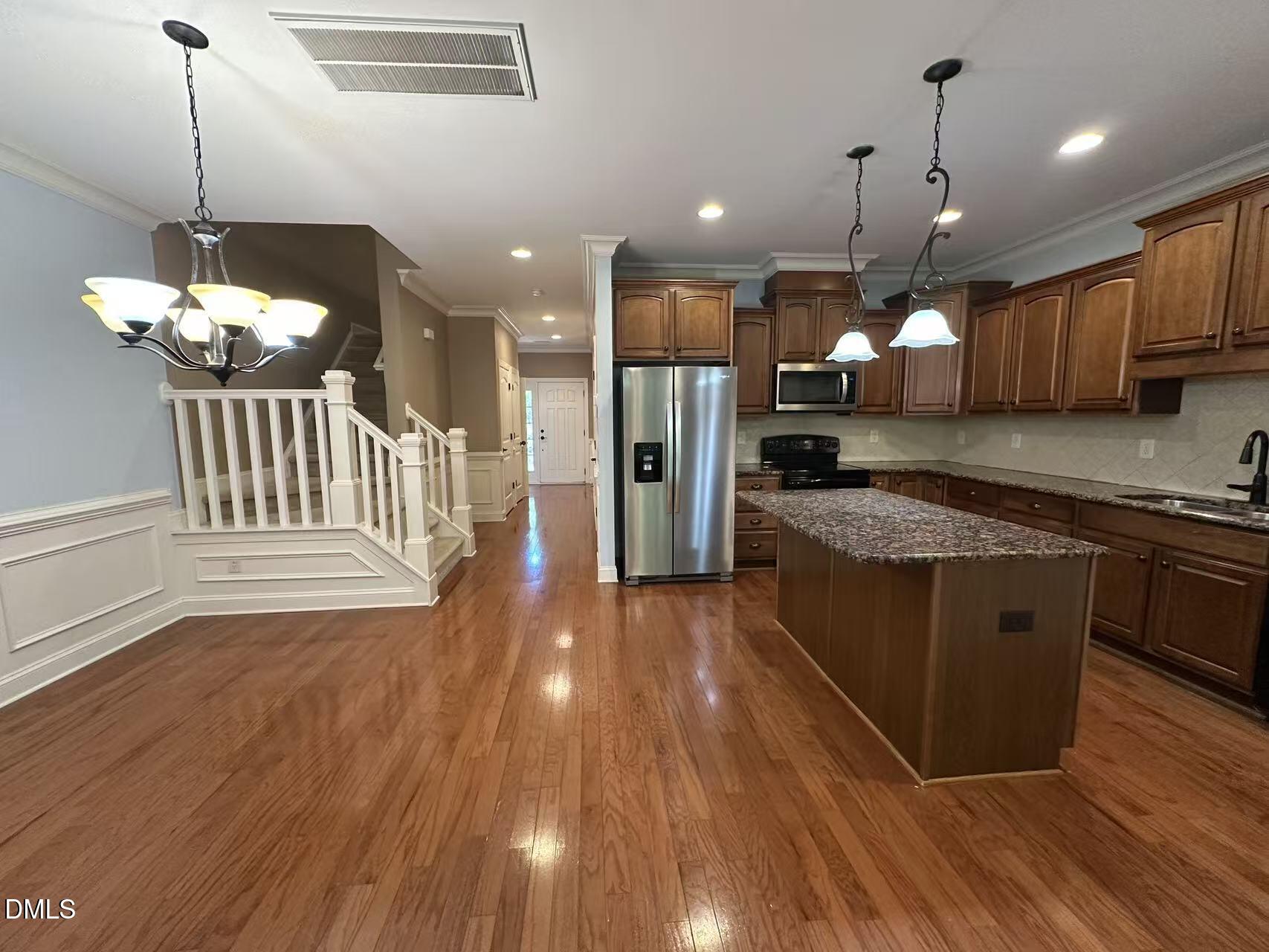1056 Indigo Ridge Place Cary, NC 27519 - Photo 8 of 33 a kitchen with stainless steel appliances granite countertop a stove a refrigerator a sink a oven and a wooden floor