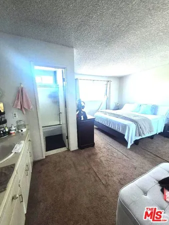 a spacious bedroom with a bed and a dresser